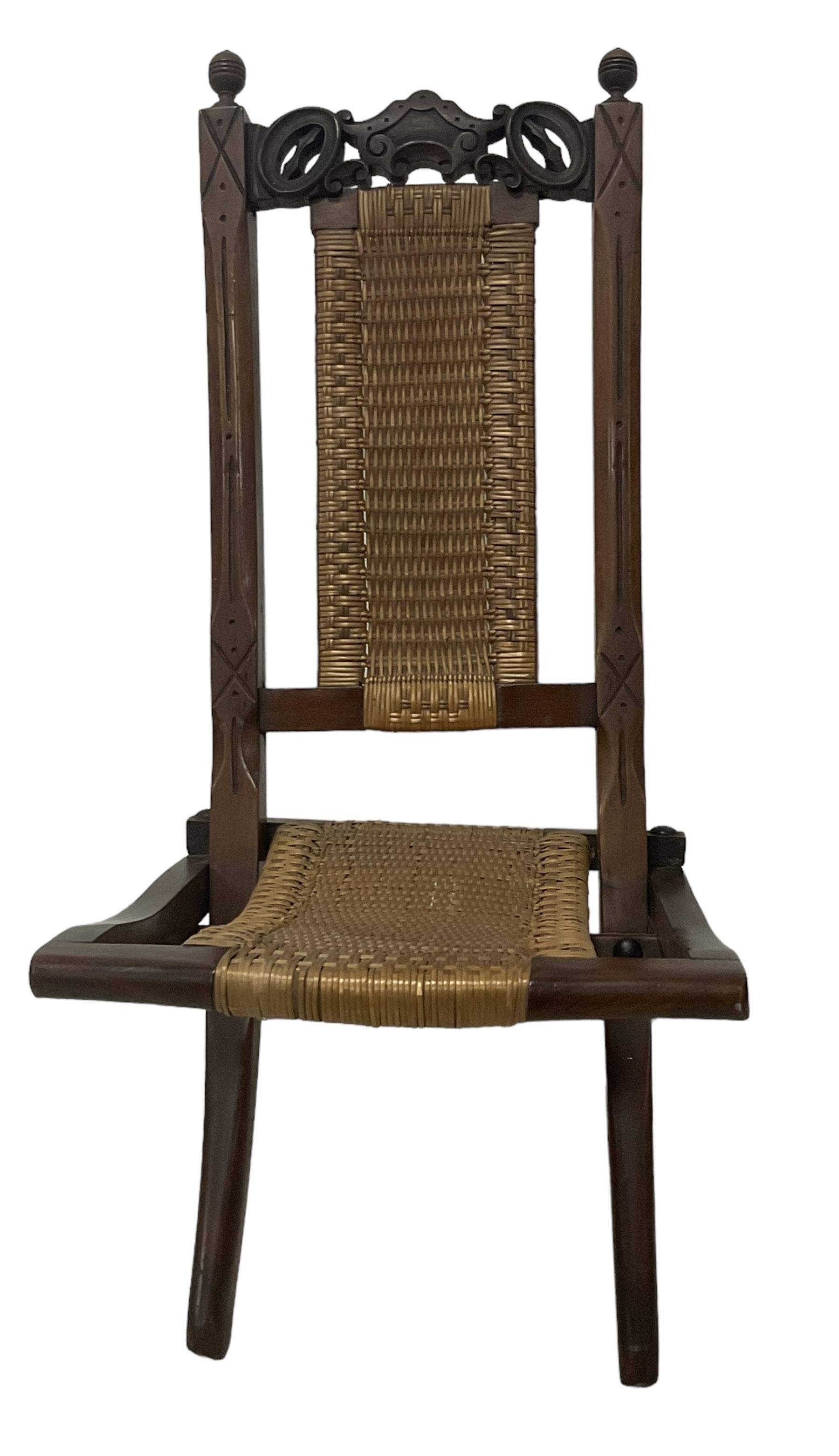 Victorian Aesthetic Movement mahogany framed folding campaign chair, pierced and carved cresting rail with carved and chamfered uprights, rattan back and seat